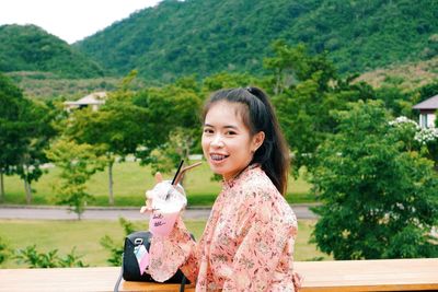 Portrait of smiling girl against trees