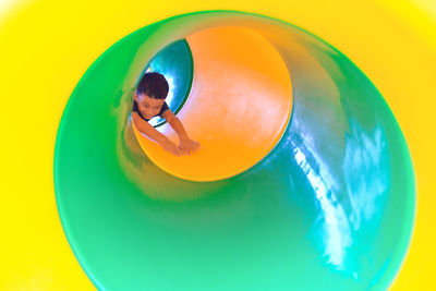 Boy playing in playground tunnel