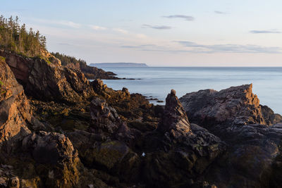 Rock formation on beach against sky