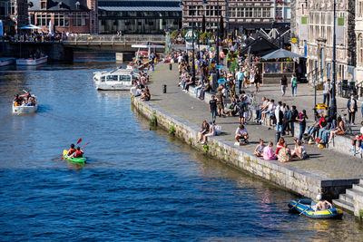 People on boats in canal along buildings