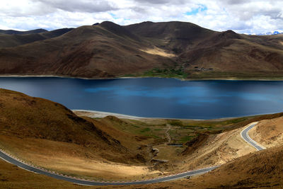 Scenic view of lake and mountains against cloudy sky