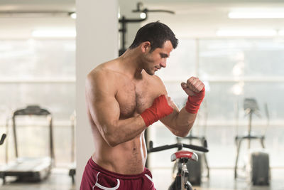 Muscular shirtless man standing in gym