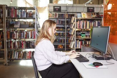 Female student using computer in library