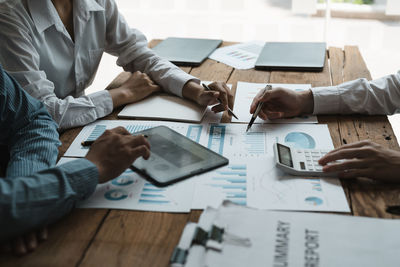 Midsection of business colleagues working at desk in office