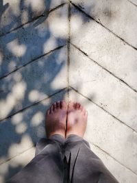 Low section of person standing on tiled floor