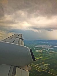 Close-up of airplane wing over sea against sky