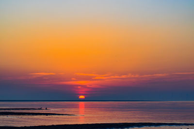 Scenic view of sea against orange sky