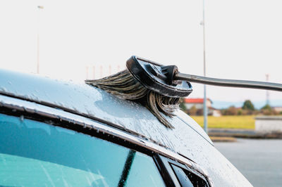 Close-up of a car washing station brush over a car covered in soap 