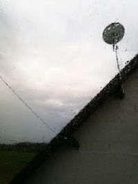 Close-up of raindrops on windshield against sky