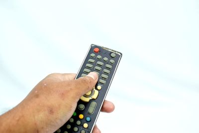 Low angle view of man using mobile phone against white background