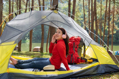 Woman enjoy listening to musicsat in a yellow tent. beside lake, pang oung, mae hong son, thailand