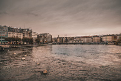 Bridge over river against buildings in city