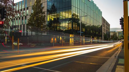 Light trails on road amidst buildings in city at night