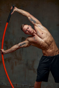 Portrait of man practicing with combat stick in gym