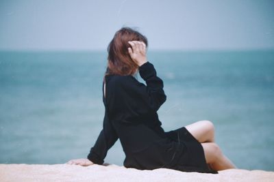 Young woman sitting at beach