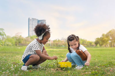 Rear view of women sitting on field