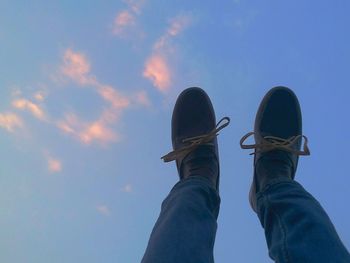 Low angle view of people against blue sky