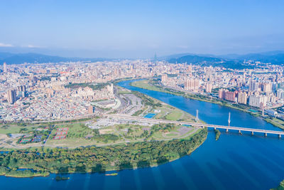 High angle view of city by sea against sky