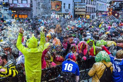 Crowd throwing colorful confetti in city during celebration