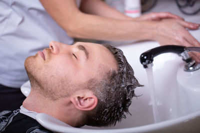 Close-up of man washing hands