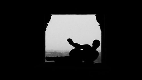 Silhouette of man with shadow on window