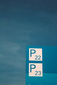 Low angle view of information sign against blue sky
