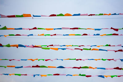 Multi colored umbrellas hanging against blue sky