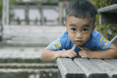 Portrait of cute boy sitting outdoors