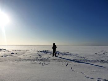 Rear view of man standing on snow covered land