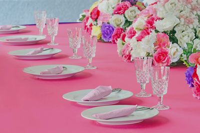 Plates and wineglasses with flowers on dinning table