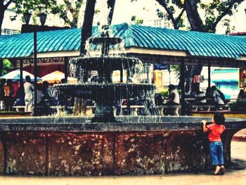 Rear view of people standing by water