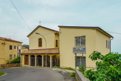 Road amidst buildings against sky