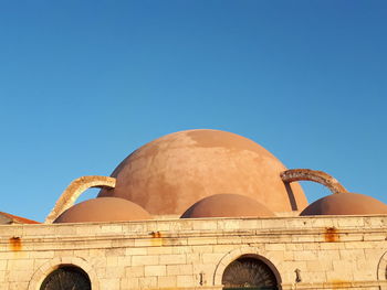 Low angle view of old building against clear blue sky