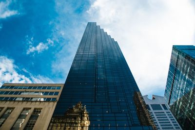 Low angle view of buildings against cloudy sky