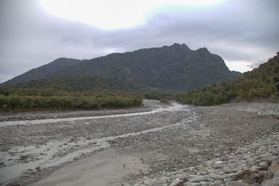 Scenic view of land and mountains against sky