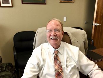 Smiling senior businessman sitting on chair at office