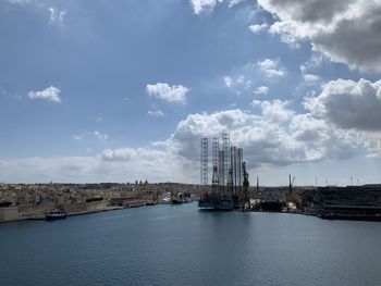 Bridge over river in city against sky