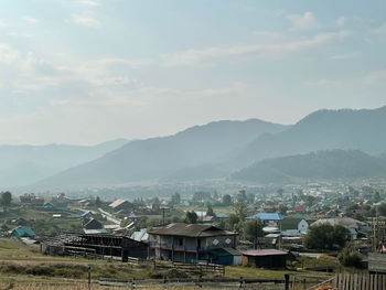 Townscape by mountains against sky