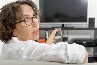 Portrait of woman watching tv at home