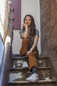 Portrait of a young woman sitting in a staircase