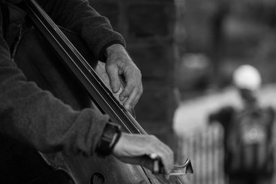 Midsection of man playing cello at central park