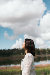 Side view of woman standing against sky