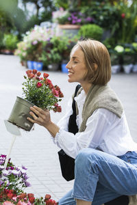 Woman holding flower pot on potted plant