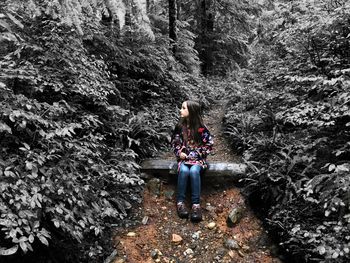 Full length of woman standing in forest