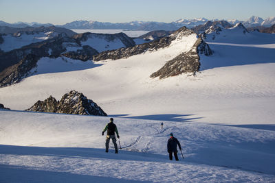 People skiing on snowcapped mountain against sky