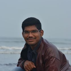 Portrait of young man by sea against sky