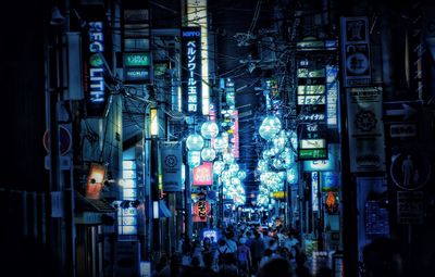 Group of people in illuminated city at night