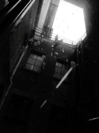 Low angle view of buildings seen through wet glass window