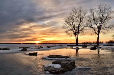 Scenic view of frozen lake against sky during sunset