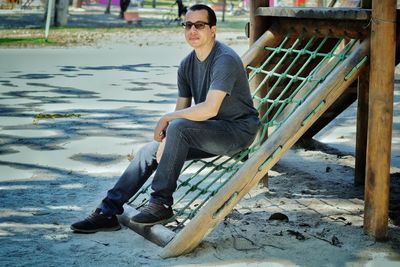 Full length portrait of young man sitting on chair